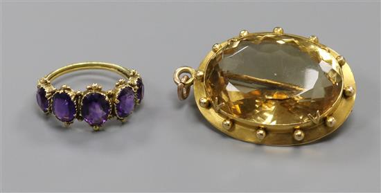 A Victorian yellow metal framed citrine brooch and a yellow metal and graduated five stone amethyst ring.